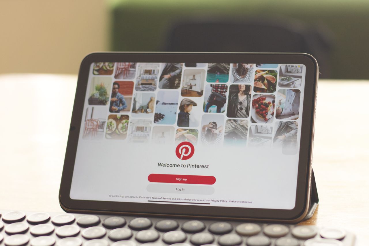 services-01 A tablet on a wooden desk showcasing the Pinterest login screen, emphasizing digital connectivity.